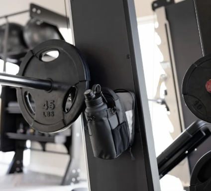 Close-up of a barbell with weight plates on a gym squat rack.