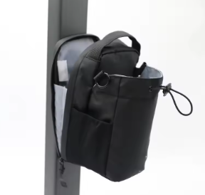 Black bag attached to a vertical metal post on a white background